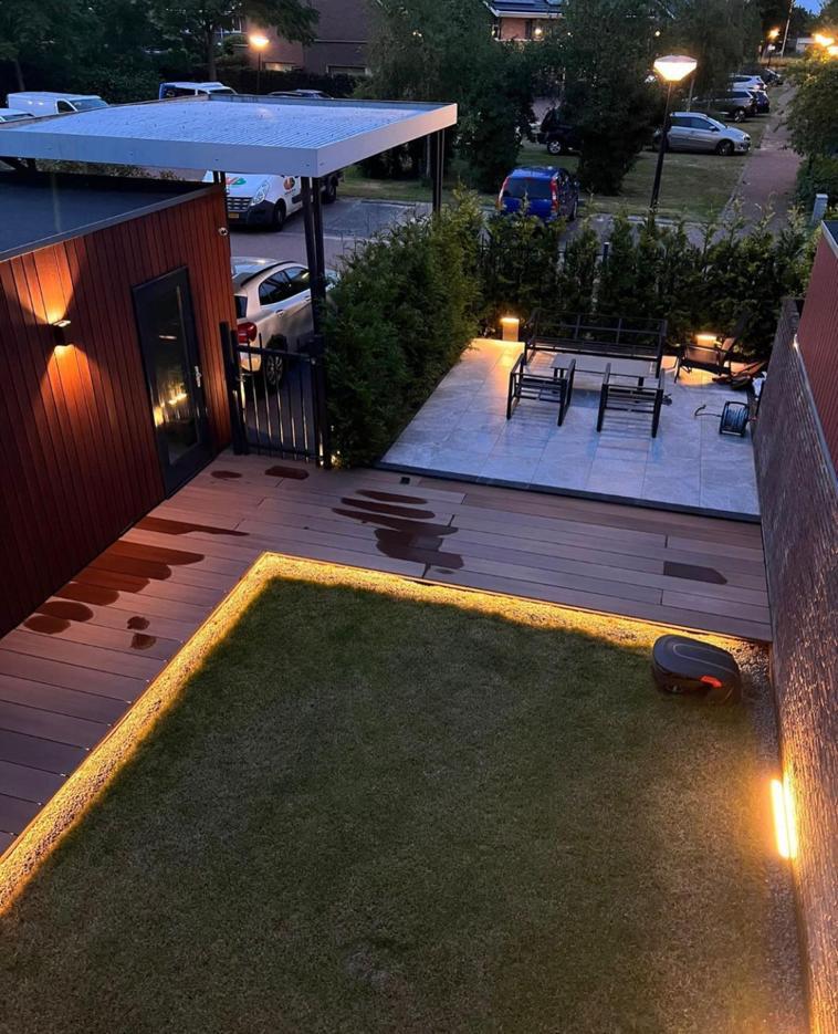 Aangelegde tuin met verlichting en houten terras